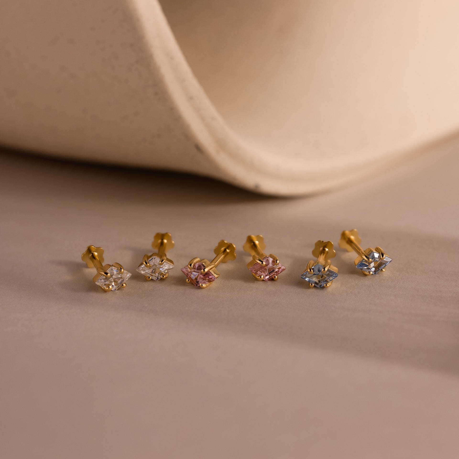 Six gold Rhombus Birthstone Flatback Studs with white, pink, and blue stones shown on a neutral background—ideal for those who love understated chic and modern glamour jewelry styles.