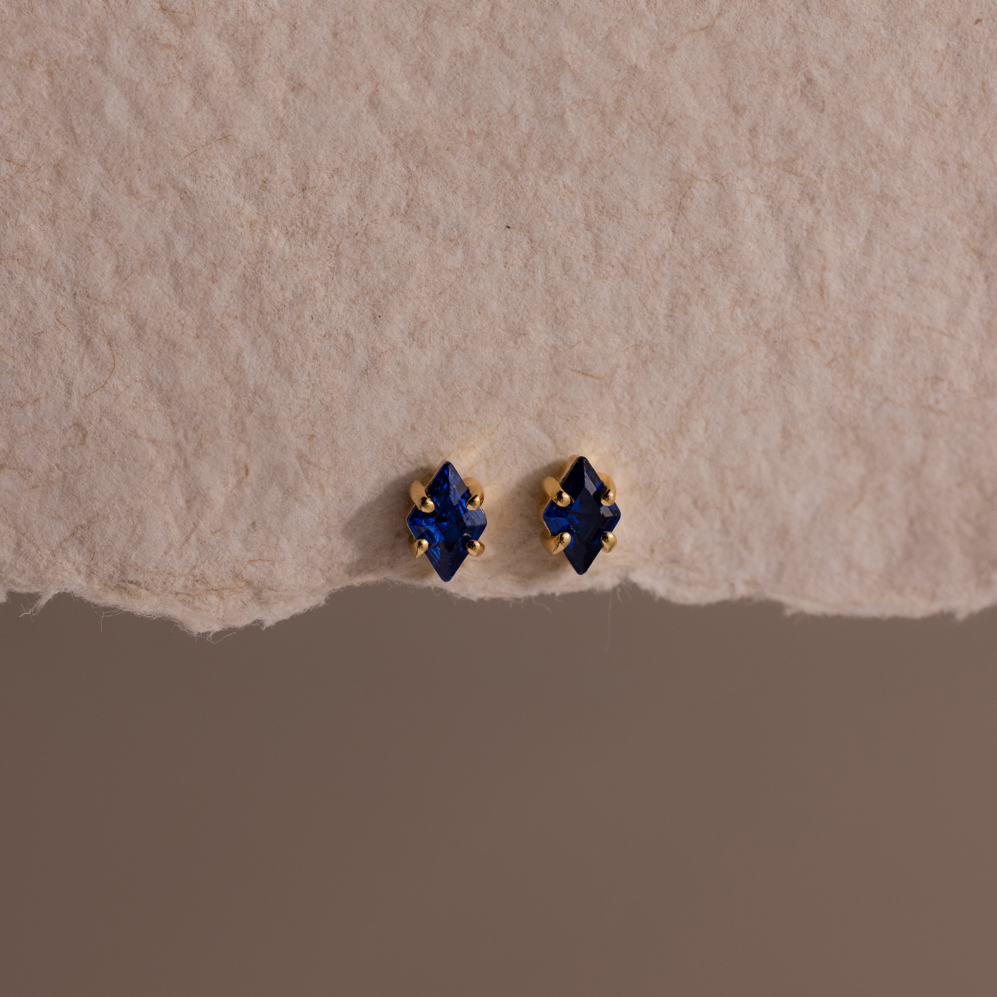 A pair of Rhombus Sapphire Flatback Studs, ideal for adding understated charm and modern glamour to any look.