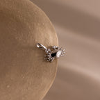 Silver crab charm pendant with gemstone eyes, displayed on a soft neutral background.