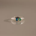The Toi et Moi Dome Ring in Silver showcases a blue rectangular gem and a green teardrop-shaped gem set side by side.