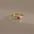 The Toi et Moi Dome Ring in 18K Gold features a rectangular clear stone and an oval pink stone set side by side on a smooth band.