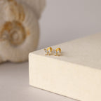 Butterfly Diamond Flatback Studs shown on a cream-textured surface—ideal personalized jewelry for any collection.