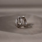 Pair of silver hoop earrings on a beige background