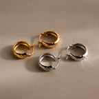 Bold Hammered Huggies in gold and silver with a textured finish are shown on a neutral background—ideal minimalist earrings for a modern look.