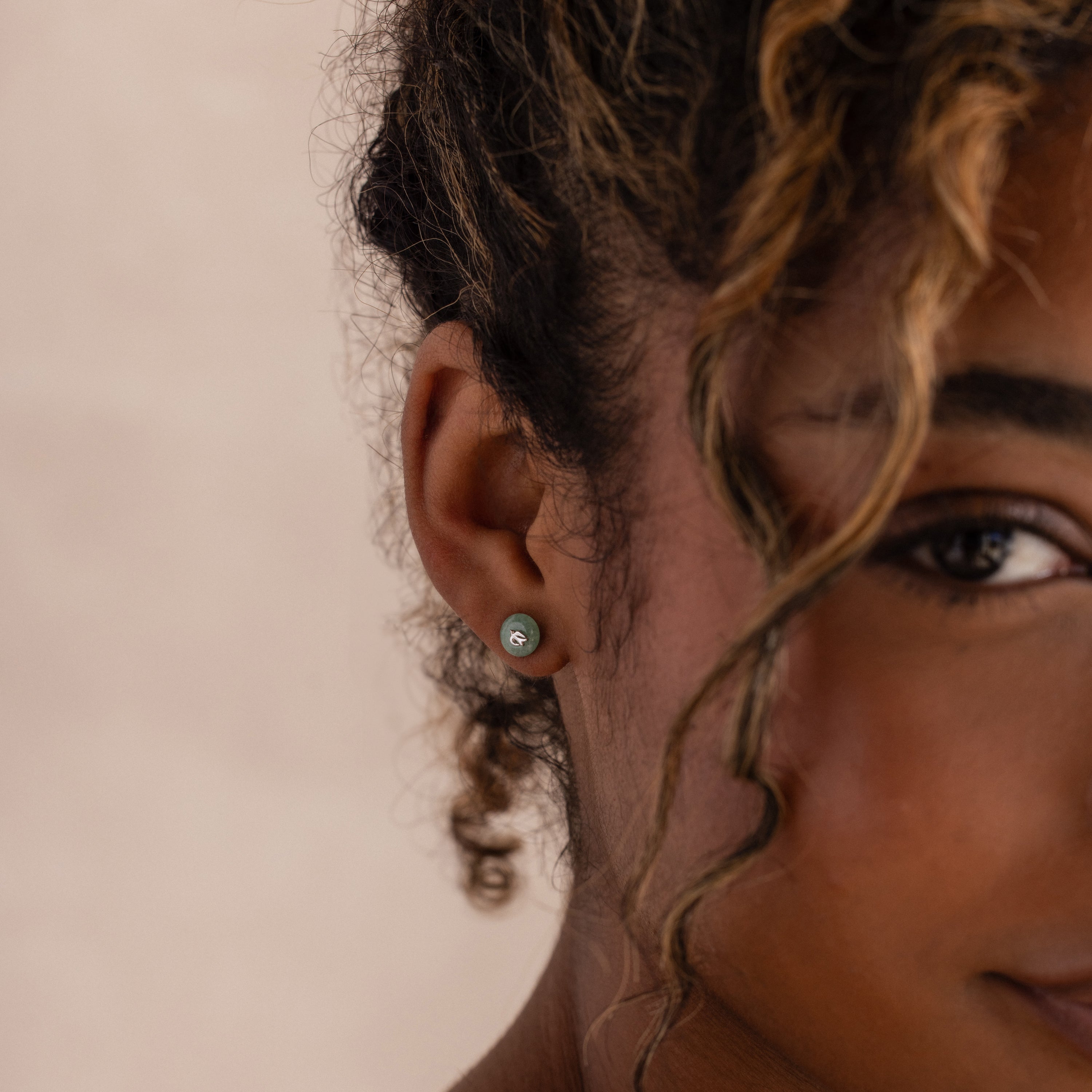 Model wearing silver Jade Bird Studs with dainty silver dove birds on round green jade discs.