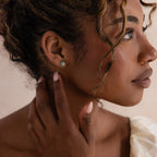 Model wearing silver Jade Bird Studs with dainty silver dove birds on round green jade discs.