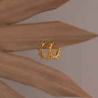 Beaded Hoops in 18K Gold shimmer elegantly on dried brown palm leaves, set against a neutral background.