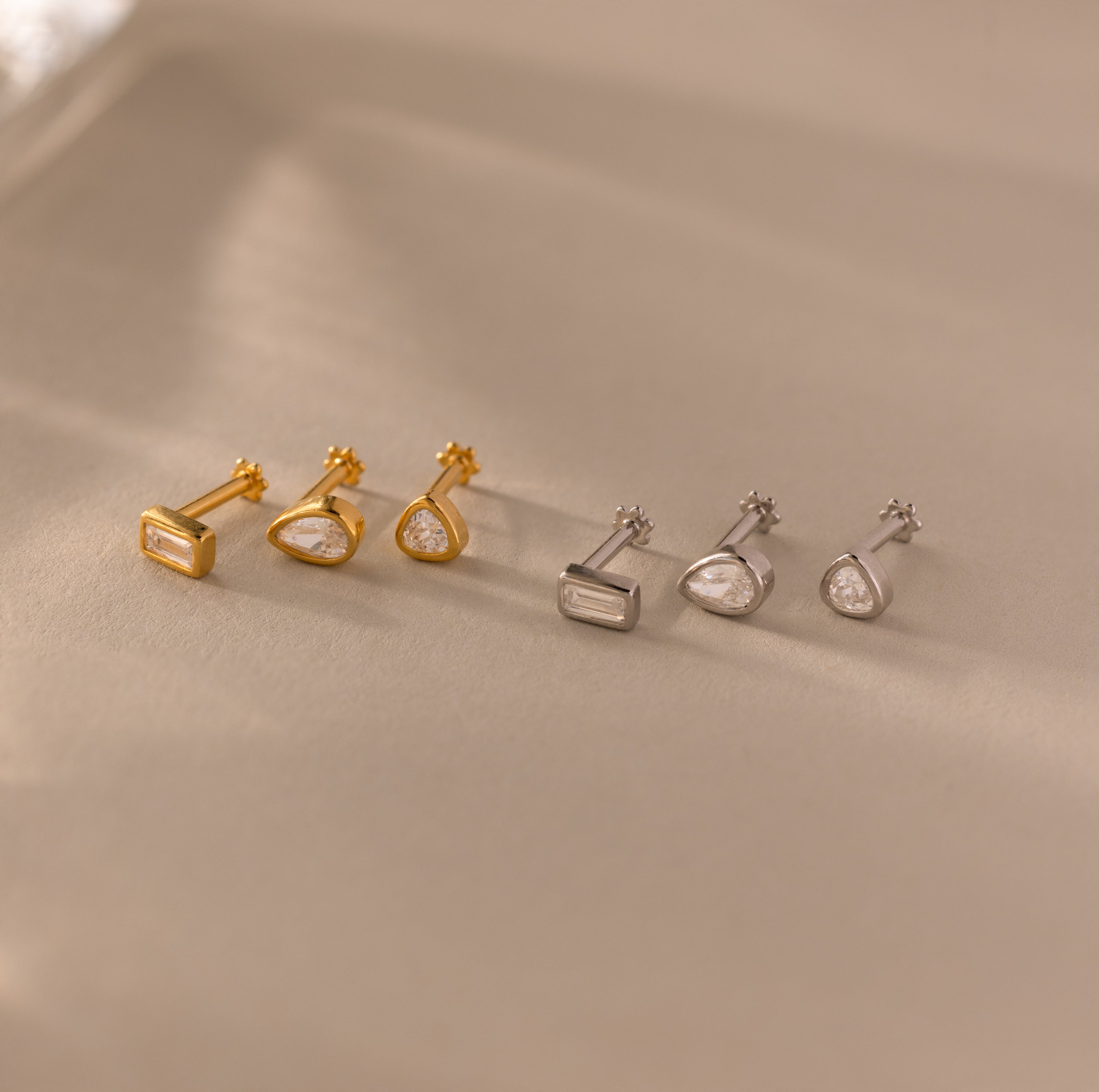 The Diamond Bezel Flatback Studs Set features six unique geometric-shaped stud earrings, in gold and silver tones—ideal for fans of classic studs or sleek, modern designs.