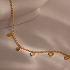 Close-up of a gold heart charm necklace with five unique heart pendants.