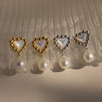 Four heart-shaped pearl beaded drop studs in 18K gold, beautifully displayed on pleated white fabric—perfect as Pearl Heart Earrings and a charming bridesmaid gift.