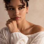 Model wearing silver geometric square hoop earrings, styled with a knit top.