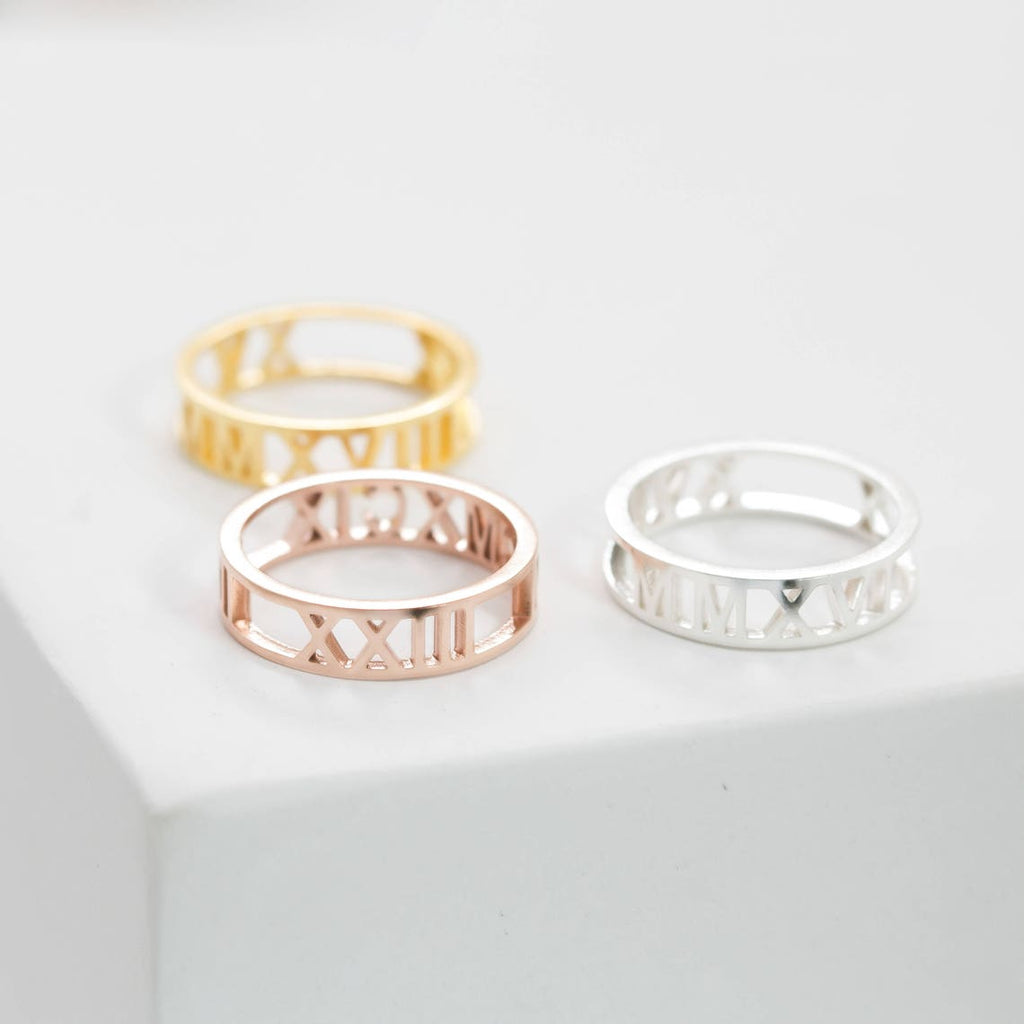 The Roman Numerals Ring in Rose Gold, featuring cut-out numerals, is perfect for celebrating a meaningful date or milestone.