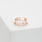 The Roman Numerals Ring in Rose Gold features elegant cut-out detailing, making it ideal for marking personal milestones or special dates. Shown on a white surface for a refined presentation.