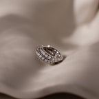 Silver hoop earrings with embedded diamond stones on a soft fabric background
