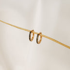 Black Onyx Hoops Bundle: gold hoop earrings with small black onyx stones, displayed on a thin beige stick against a light background.