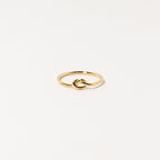 The Knot Ring in 18K Gold features a delicate knot design at the center, shown on a white background—ideal as a meaningful symbol or an elegant wedding gift.
