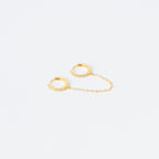 The Diamond Chain Earrings Set features two small gold hoops linked by a delicate chain, each adorned with clear stones for extra sparkle.