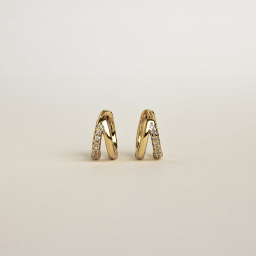 Product display of Amelia Duo Huggies in 18K Gold standing upright on a light background.