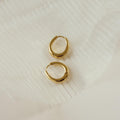 The Paris Oval Hoops in 18K Gold bring timeless elegance to any look with their classic design.