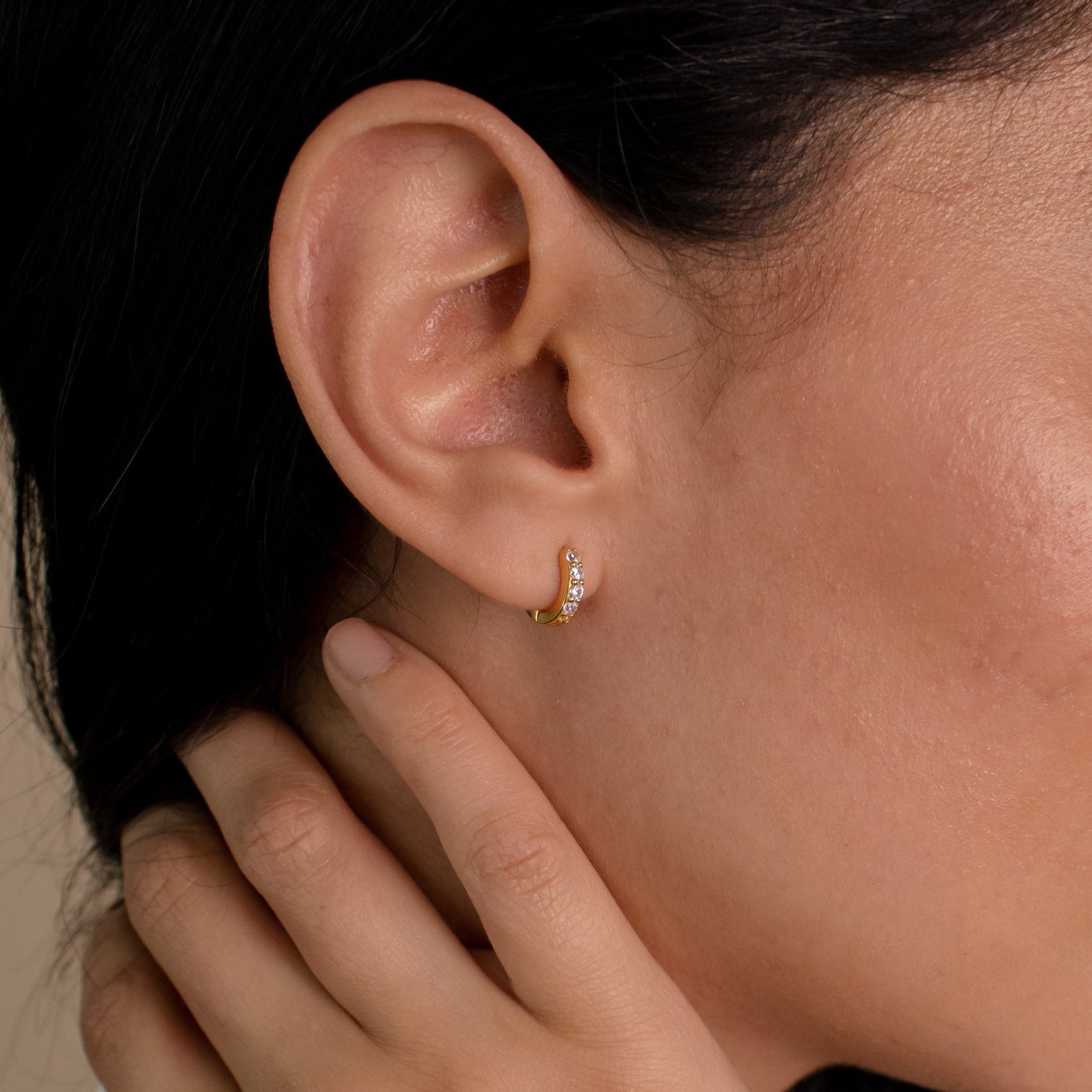 A close-up of a woman's ear adorned with Elise Diamond Huggies.