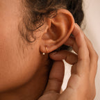 Jady Wire Diamond Hoop earring in 18K gold with pavé diamonds worn on pierced ear, close-up view.
