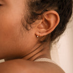 Single 18K gold Jady Wire Diamond Hoop earring with a delicate pave diamond setting on a model's ear.