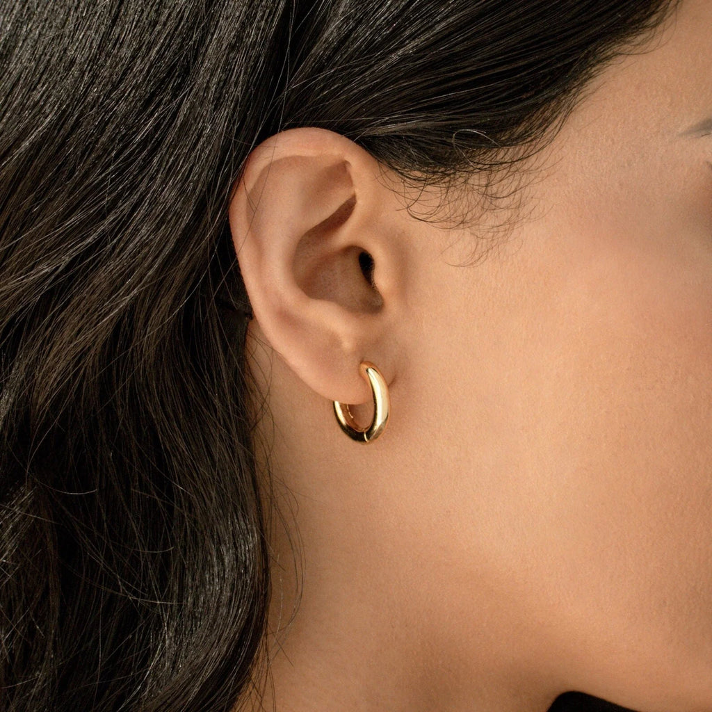 A close-up of a woman's ear with straight dark hair shows her wearing the Diamond Butterfly Earrings Set—ideal for layering or pairing with small gold hoops for a chic, delicate look.