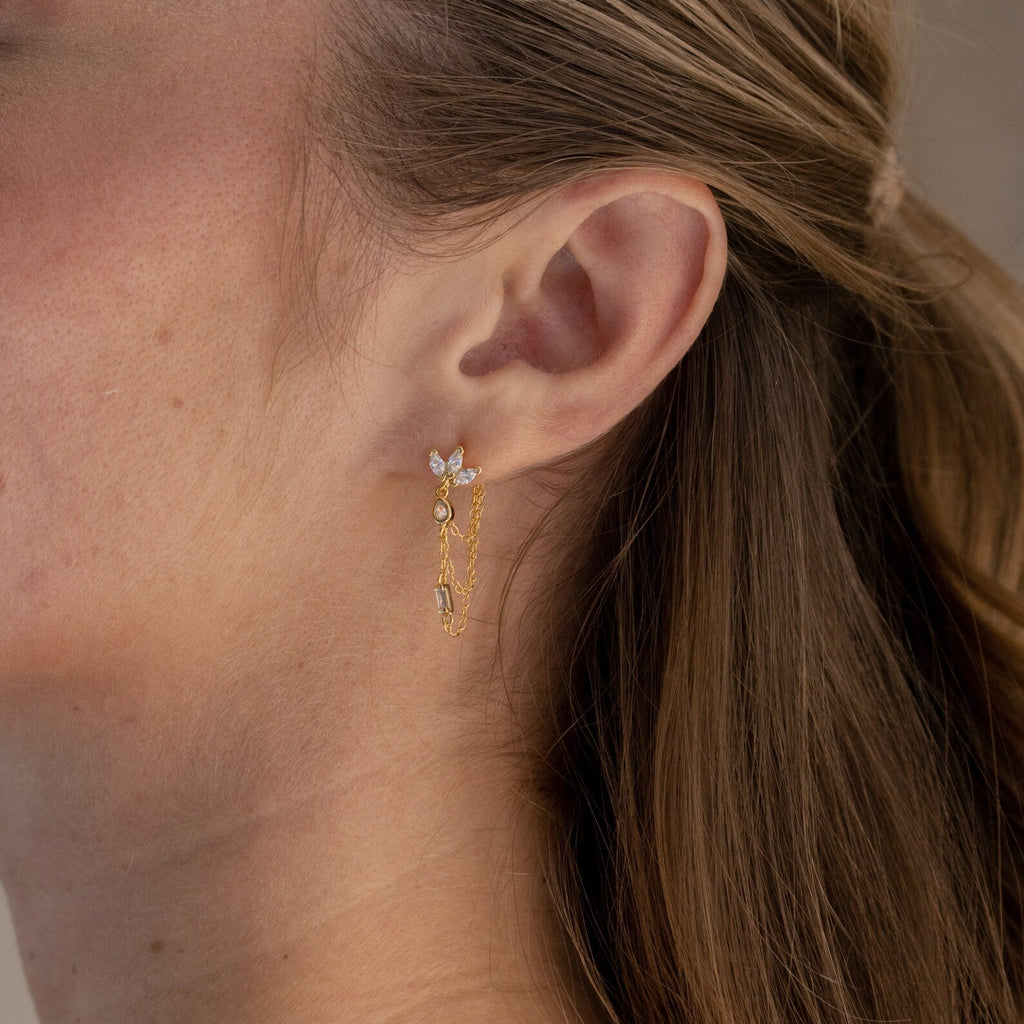 Close-up of a woman's ear with the Diamond Chain Earrings Set, featuring delicate gold chains and small gemstones.