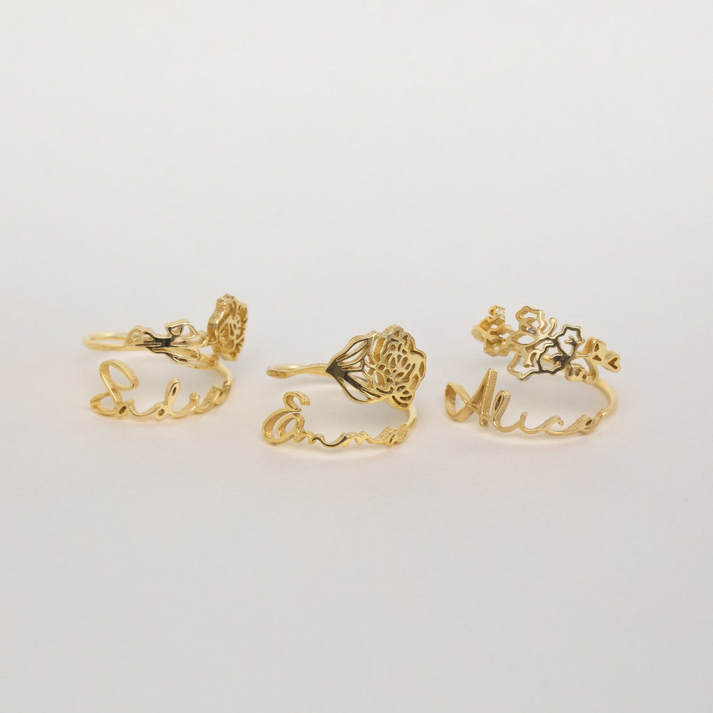 Three gold Flower Name Rings with floral designs, each engraved with a different name—Lilu, Emma, and Alice. This meaningful personalized jewelry set is the perfect gift for mom to celebrate her loved ones.