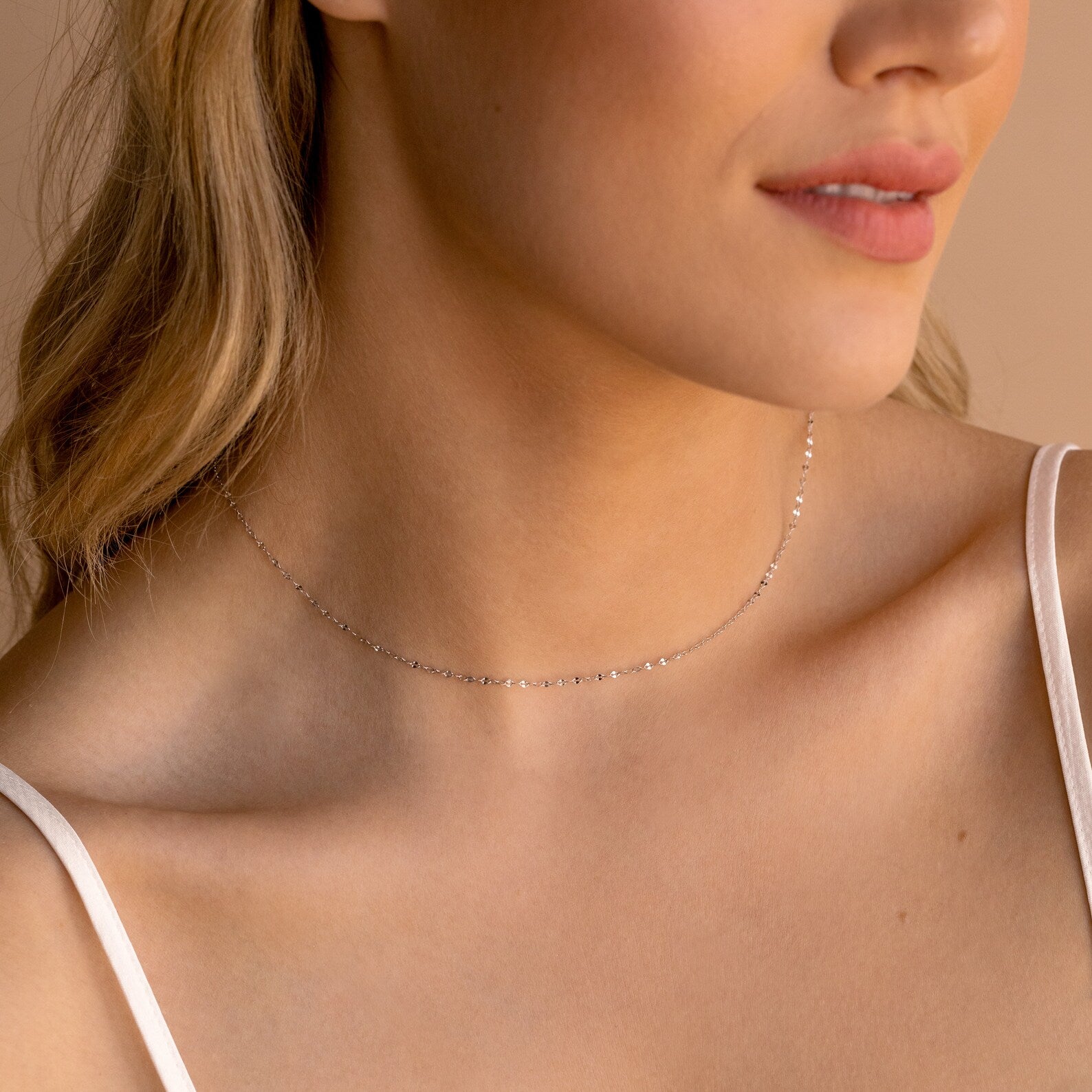 A woman wears a delicate silver Josephine Chain Necklace choker with a white spaghetti strap top, making it perfect wedding jewelry.
