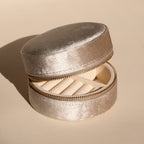 The Round Velvet Jewelry Case in light beige features a zipper and organized ring compartments, making it an ideal minimalist jewelry box and travel organizer.