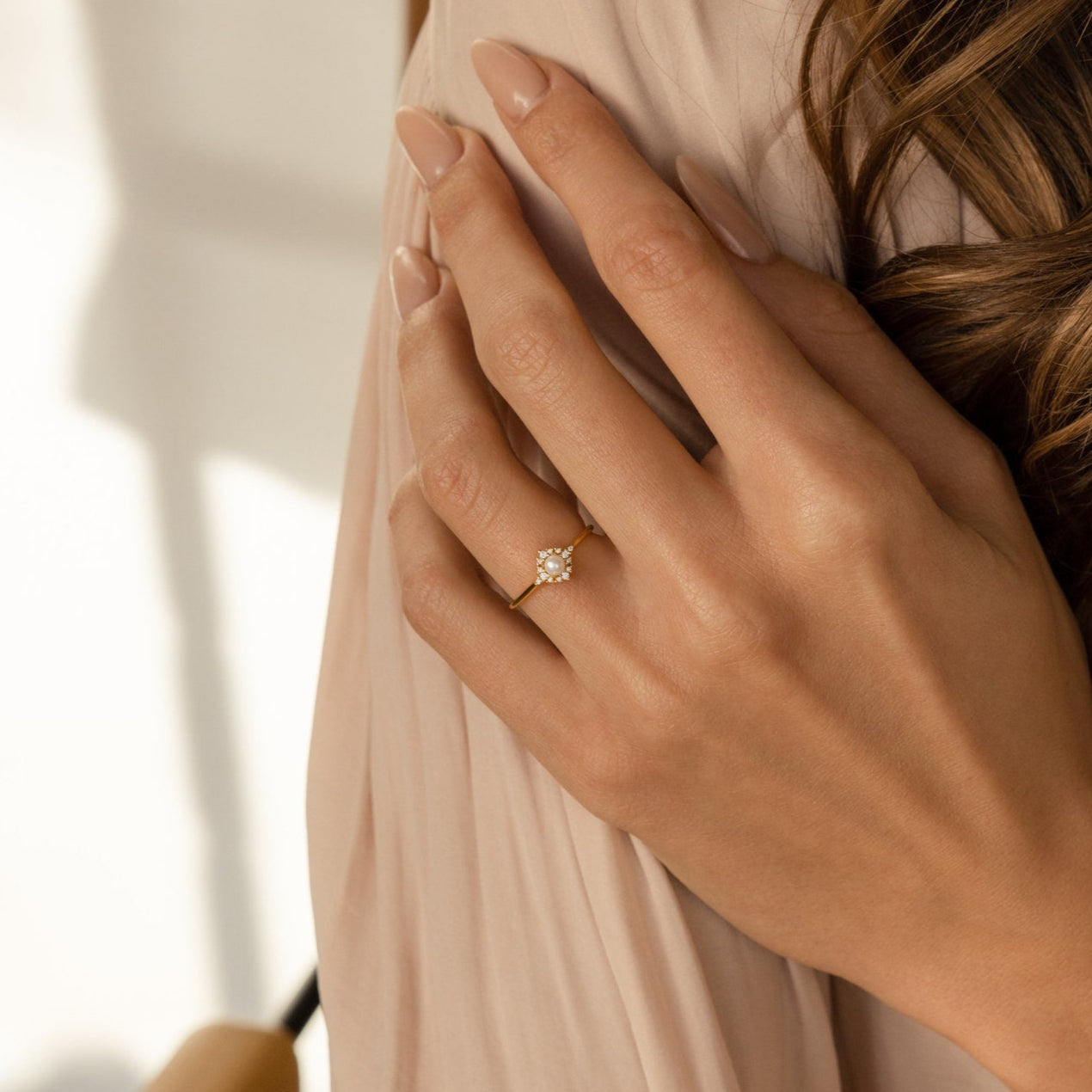 A woman's hand with nude nails wears the Vintage Pave Pearl Ring in Sterling Silver on her ring finger, featuring a clear gemstone—making it a perfect Christmas gift.