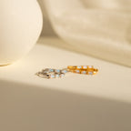 Two pairs of Halo Opal Hoops, minimalist huggie earrings in silver and gold finishes, displayed on a light-colored surface.