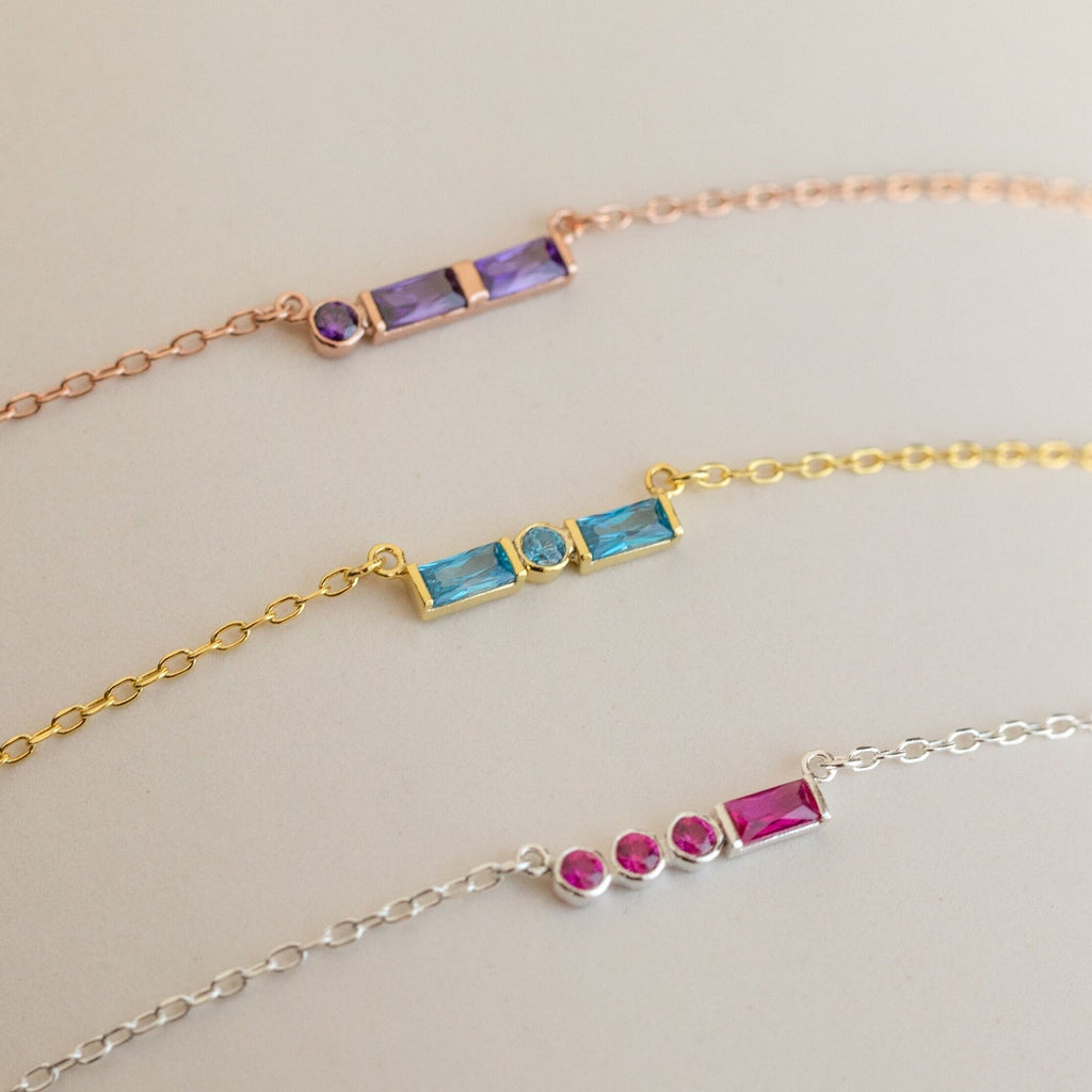 Three delicate chain bracelets with colorful rectangular gemstones in rose gold, gold, and silver—perfect for stacking with your favorite Initial Morse Birthstone Necklace or other personalized jewelry.