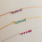 Three delicate chain bracelets with colorful rectangular gemstones in rose gold, gold, and silver—perfect for stacking with your favorite Initial Morse Birthstone Necklace or other personalized jewelry.
