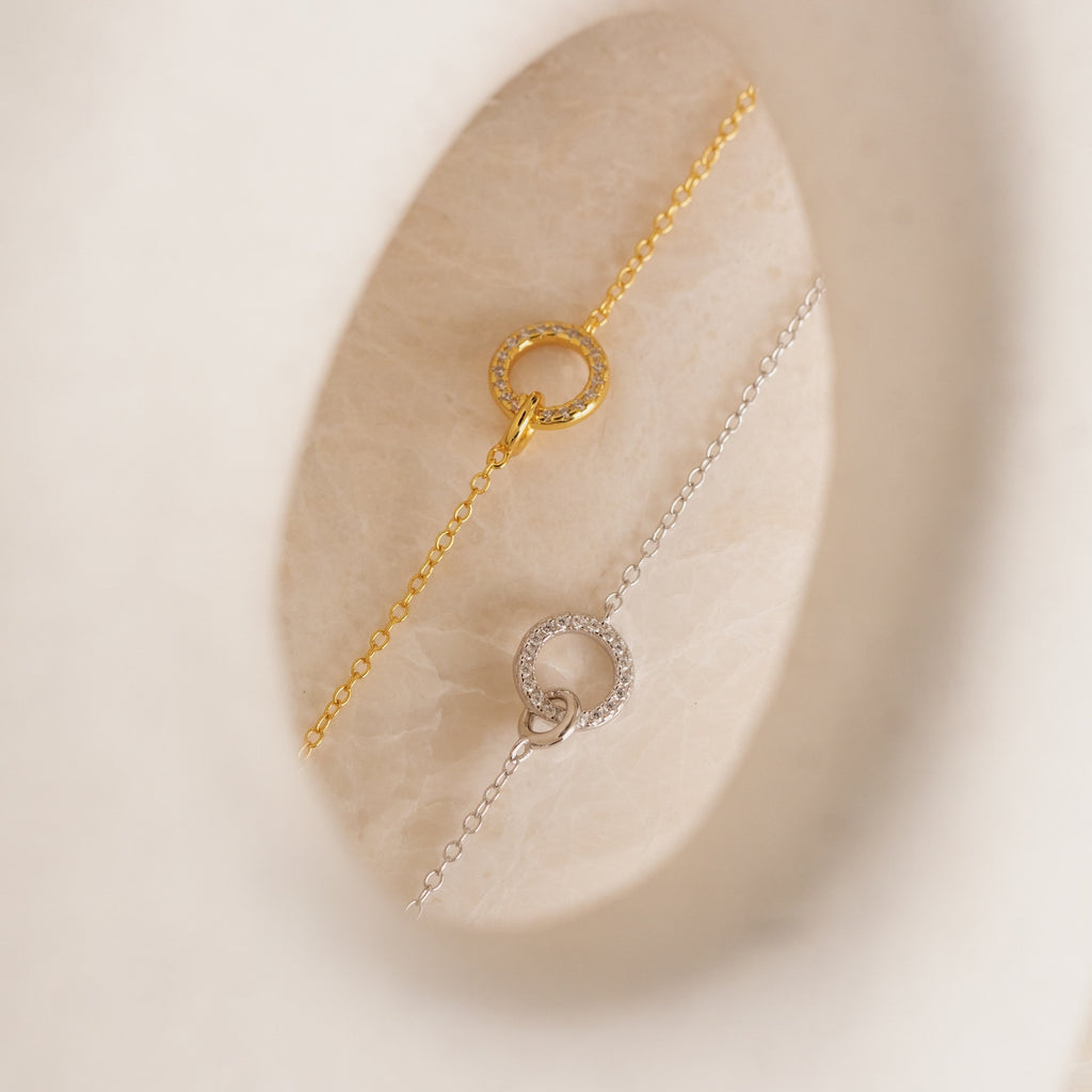 The Pave Interlocking Necklace features gold and silver chains with crystal-studded circular pendants—ideal as a dainty charm necklace or a thoughtful wedding gift for lovers of minimal diamond jewelry.