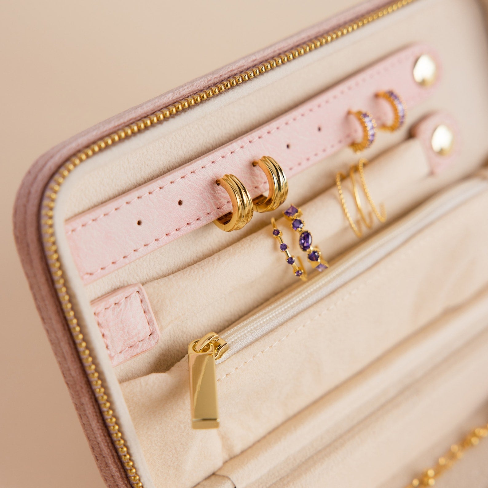 Close-up of gold earrings in a Rectangle Velvet Jewelry Case with a zipper and small pocket, perfect for keeping your treasures safe.