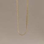 The Men's Snake Chain Necklace hangs against a plain, neutral background, showcasing minimalist elegance and timeless style—an ideal choice for men’s jewelry.