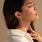 A woman with her eyes closed wearing elegant Moonstone Drop Earrings—an ideal graduation gift for fans of minimalist jewelry.