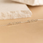 Two silver name necklaces with Mateo and Aiden on a neutral beige surface with a stone background—ideal for pairing with your favorite minimal jewelry or the Petite Tiny Multiple Name Bracelet.