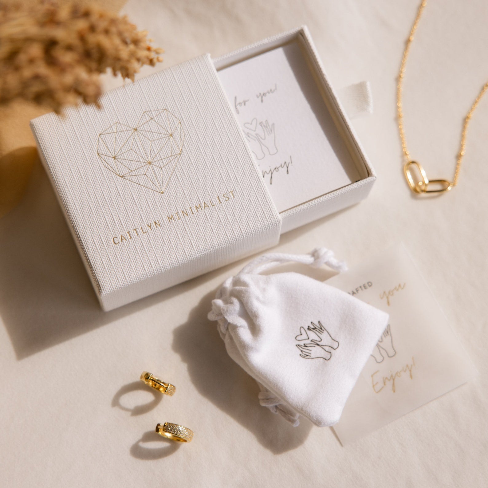 The Aquamarine Stacking Ring Set includes gold minimalist rings, an aquamarine stacking ring, necklace, white pouch, and a gift box with a geometric heart—ideal for fans of boho rings and ocean blue gemstones.