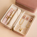 Open Rectangle Velvet Jewelry Case in pink with gold rings, bracelets, earrings, and a heart pendant necklace inside.