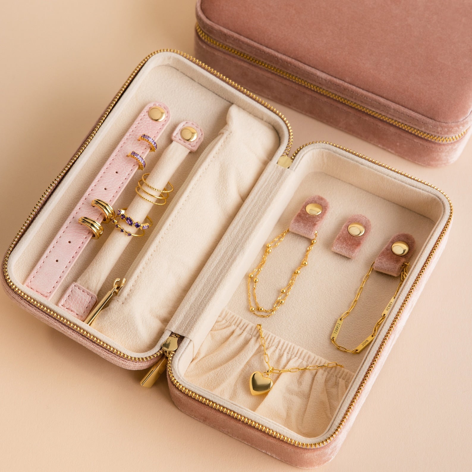 Open Rectangle Velvet Jewelry Case in pink with gold rings, bracelets, earrings, and a heart pendant necklace inside.