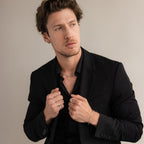 A man in a black suit and shirt wears the Thick Half Round Fingerprint Ring and silver jewelry, gazing to the side against a plain background.