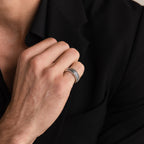 A person in a black suit touches their collar, displaying the Thick Half Round Fingerprint Ring on their finger.