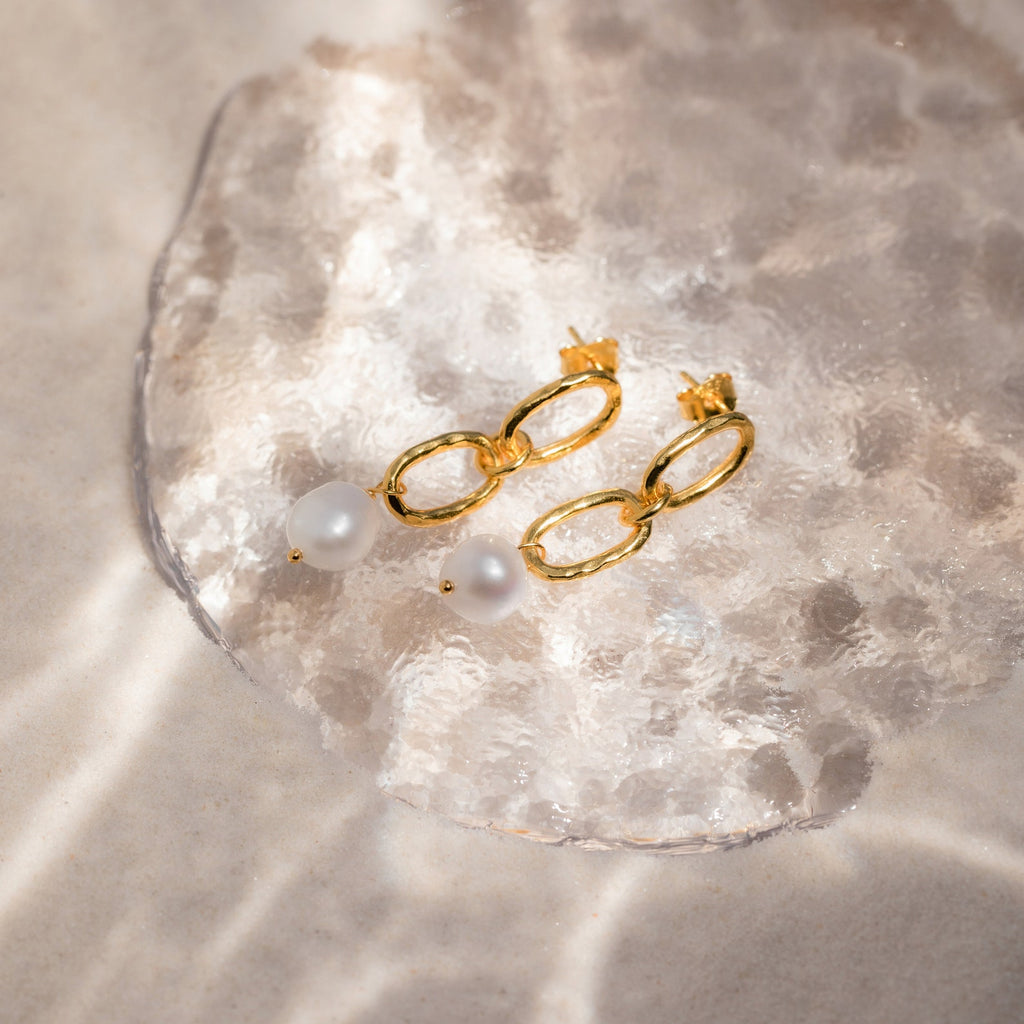 Pearl Drop Link Studs showcased on a translucent textured surface in soft sunlight, making them the ideal statement earrings for any occasion.