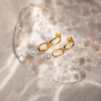 Pearl Drop Link Studs showcased on a translucent textured surface in soft sunlight, making them the ideal statement earrings for any occasion.