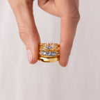 A hand displays the Aquamarine Stacking Ring Set, featuring boho rings with ocean blue gemstones, against a neutral background.