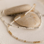 Pair the Dainty Pearl Beaded Anklet, featuring gold, silver, and pearl beads, with your favorite necklace for an effortlessly elegant look.