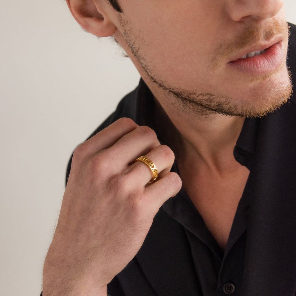 A man in a black shirt displays the Roman Numerals Ring on his hand, with his face partially visible.
